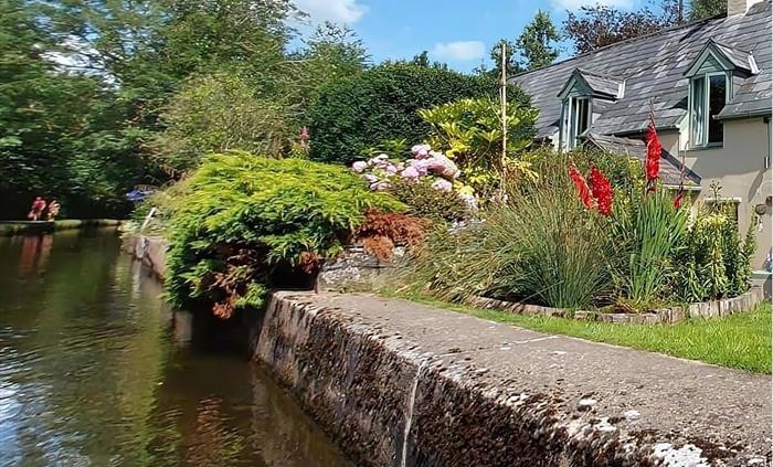 Canal side scenic view as the horse drawn boat travels a long the Llangollen canal surrounded by trees and flowers surrounding one of the canal side c